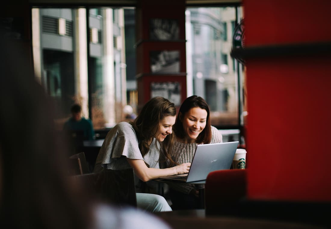 A team huddled around a laptop at an evening tech event